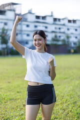 Young woman celebrating success with arms raised outdoors