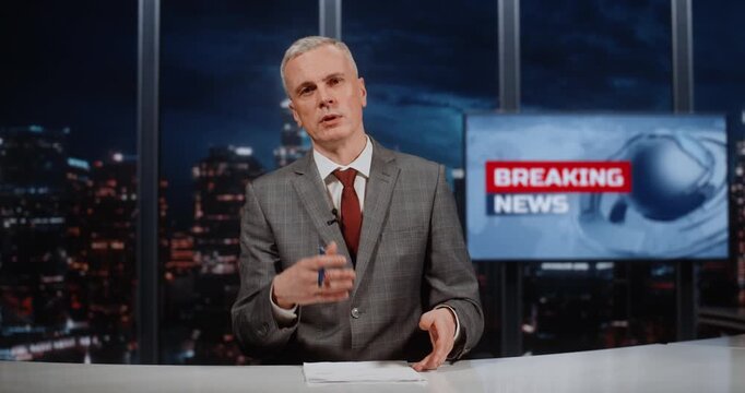 Professional Grey Haired Host of Country Main News Marathon Works Live, Covering Key World Events With Breaking News Screen Nearby. Concept of Urgency of Information and Continuous Broadcast Format.