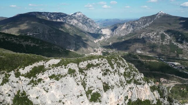 Aerial drone footage over Frasassi Gorge, Italy: rocky cliffs, green vegetation and dramatic natural landscape. Ideal for travel, nature and geological projects.