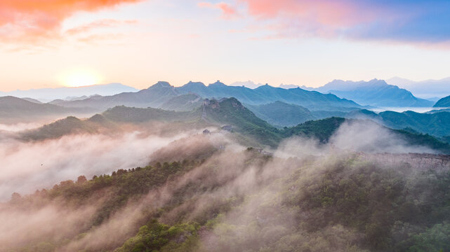 Jinshanling Great Wall rising above clouds and mist at sunrise in Hebei Province, China.
