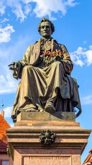 Fototapeta premium A bronze statue of a man sitting on a pedestal
