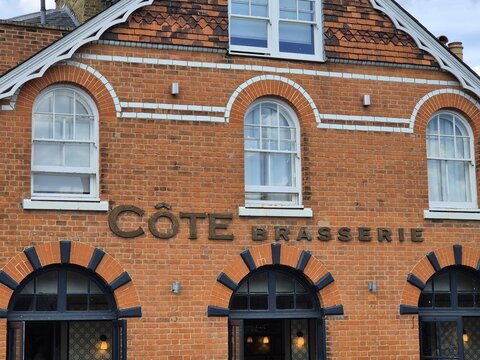 London, UK 03.07.2025 facade of C&ocirc;te Brasserie restaurant with brick architecture arched windows and signage on historic building exterior in urban environment