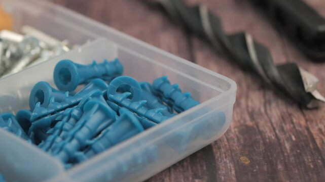 Close up of construction hardware in toolbox screws anchors and drill bits.