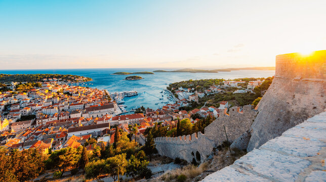 Stunning sunset over Hvar town and Pakleni Islands viewed from the medieval Spanish Fortress, golden hour over the Adriatic sea, Croatia.