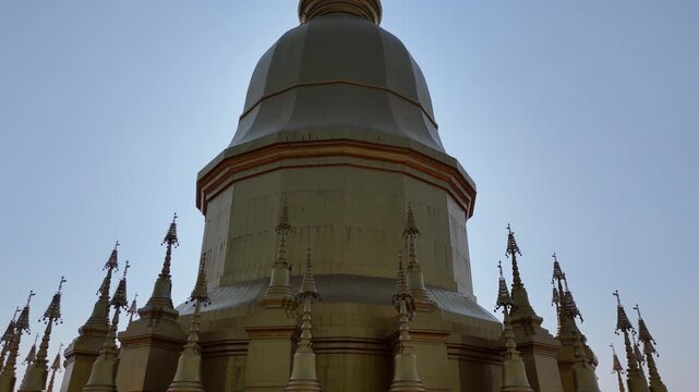 Cinematic 4k drone shot of the magnificent golden pagoda and wooden architecture at Wat Pa Wang Nam Yen, Maha Sarakham, Thailand.