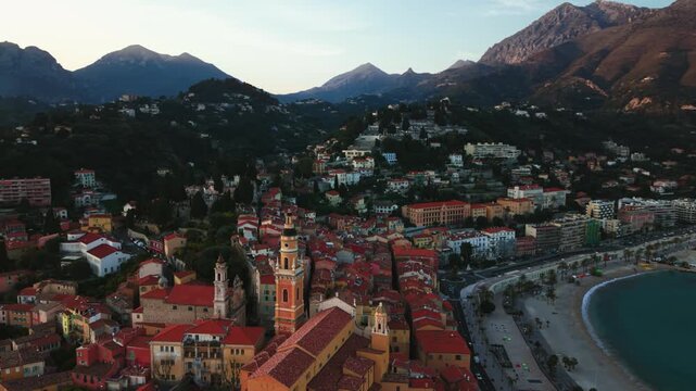 Menton Basilique Saint-Michel above colorful baroque rooftops, Mediterranean sea, France, aerial drone