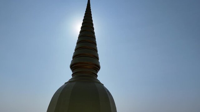 Cinematic 4k drone shot of the magnificent golden pagoda and wooden architecture at Wat Pa Wang Nam Yen, Maha Sarakham, Thailand.