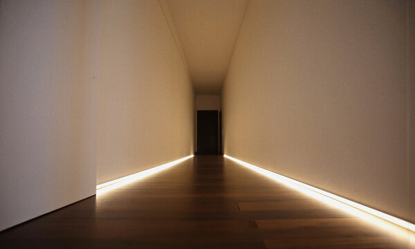 Hallway lighting interior featuring warm LED baseboard strips in a modern minimalist residence corridor leading to a dark doorway