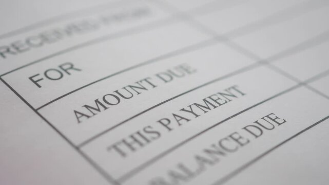 Macro view of payment receipt document with focus on amount due this payment and balance due.