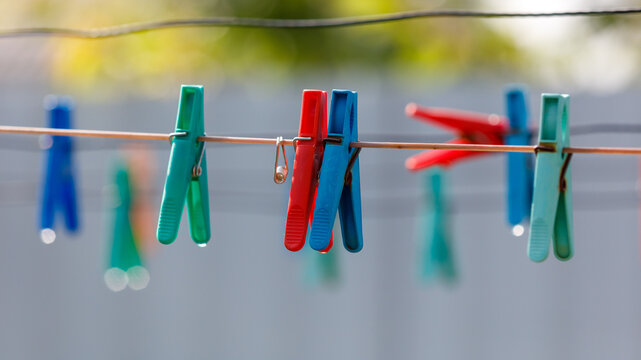 A line of clothespins hanging on a clothesline