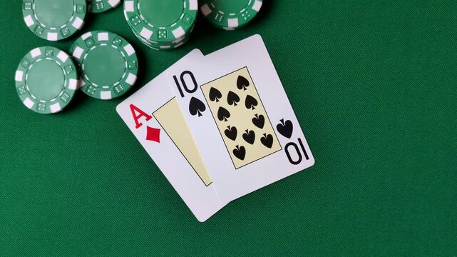 Playing cards and chips on a green cloth, a gambling game of blackjack or baccarat. Cards and chips on a gaming table as a background for your design