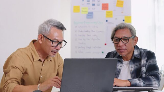 Senior developer team celebrates success in software collaboration and coding at a modern computer workstation