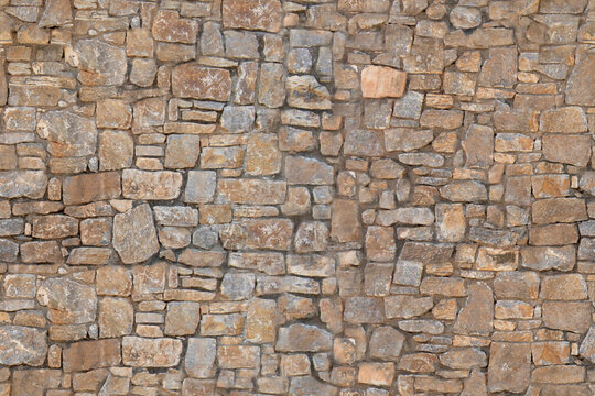 Stone wall made of irregular shaped bricks in outdoor setting