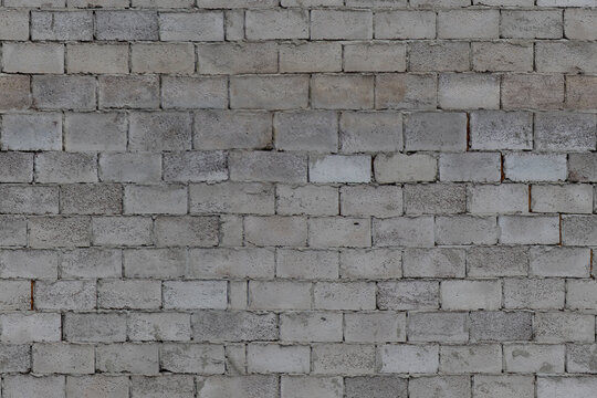Gray brick wall with rough texture in outdoor daylight setting