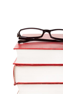 Stack of books with glasses on top front view isolated white background macro vertical