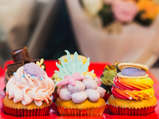 A row of gourmet ocean themed cupcakes featuring intricate fondant decorations like seashells and...
