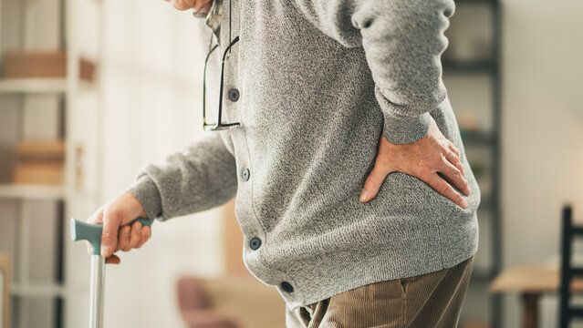 Elderly man with walking stick in home