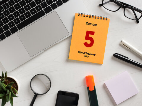 Celebrating world teachers' day: desk arrangement with laptop, calendar, and stationery