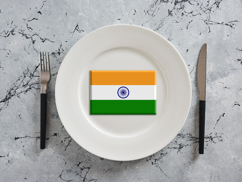 Indian flag resting on empty white plate with fork and knife
