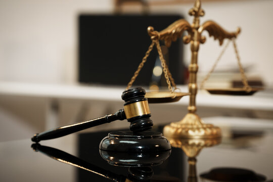 Antique brass balance scale with chains and empty pans on a desk, legal concept, justice and law symbolism, minimal neutral background with copy space.