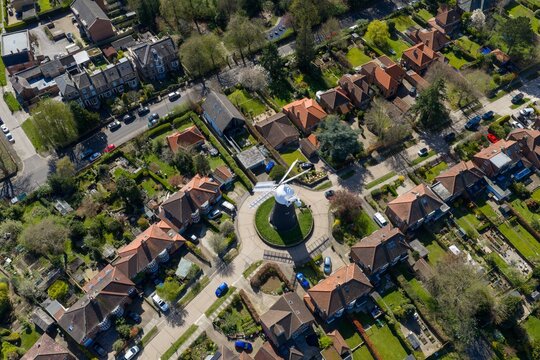 Aerial view of the city of York UK suburb with a windmill house on a roundabout surrounded by detached homes gardens and streets forming a neat residential pattern in a calm neighbourhood setting