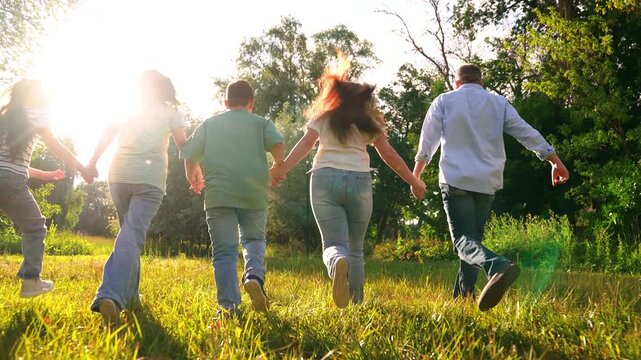 Mother father child kid run towards sunset park, happy family, running dad mom girl boy son daughter, group people run holding hands, one bright path, weekend escape in the countryside, unity in