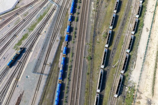 Aerial view of railway yard in the city of York in Yorkshire UK with parallel tracks blue and brown freight wagons and gravel ground forming a structured industrial transport scene from above