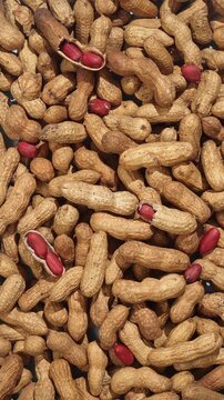 Raw peanuts in shell with gradual light changes creating natural texture pattern and organic food background