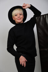Obraz premium Selbstbewusste Best-Ager Frau in schwarzem Outfit mit stilvoller Pose, modernes Fashion- und Lifestyle-Porträt mit Copyspace