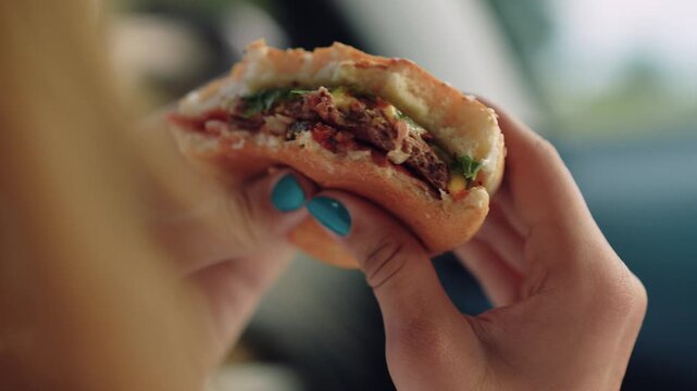 woman girl eating burger car, happy person, Woman takes bite of hamburger, Eating fast food in car, Roadside lunch break, Juicy hamburger for traveler, Meal during commute, Delicious street food
