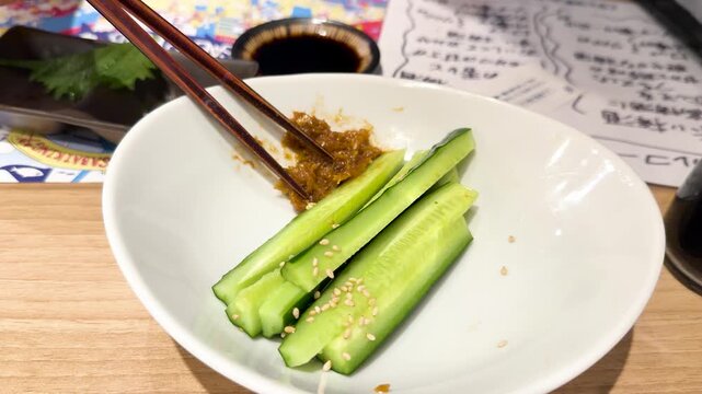 Chopsticks Dipping Fresh Sliced Cucumber into Miso Paste in Kanazawa Japan