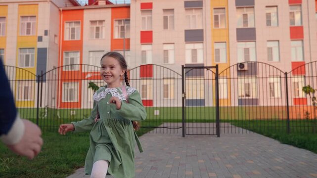 child girl kid daughter runs. schoolgirl with backpack hugs happy father father man. joyful smile face parent. child kid girl hugs father outdoors. family love feelings hugs trust. good relationship