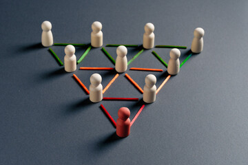 Obraz premium Abstract metaphor of leadership and connected networks using wooden figures and intersecting colorful lines.