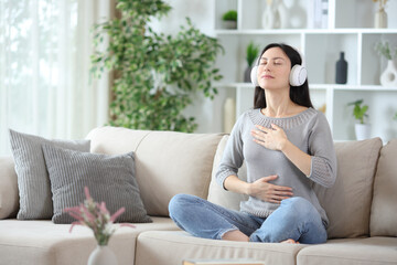 Obraz premium Asian woman wearing headphone doing breathing exercises
