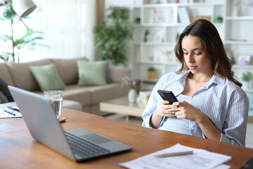 Distracted employee using phone while teleworking at home