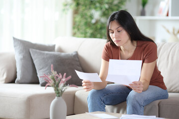 Suspicious asian woman checking bill or bank statement