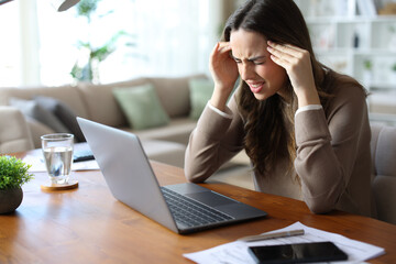 Stressed tele worker suffering migraine attack working at home
