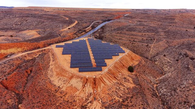 Large scale solar power plant with rows of photovoltaic panels installed on red clay terrain in the semi-arid steppe region of Aragon Spain