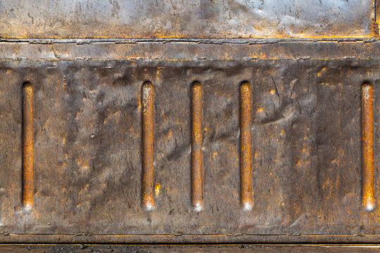 Rusty distressed sheet metal panel with stiffening ribs and rusted textured surface