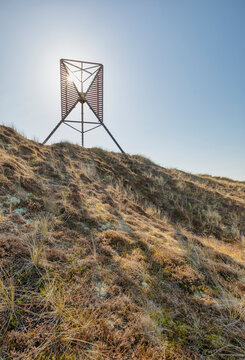 Old wooden beacon on the shore of Rinkg&oslash;bing inlet at Hvide Sande, Holmsklit spit, Denmark, in bright sunlight