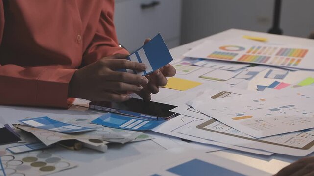 Asian uxui designer working on website design using sticky notes and wireframes