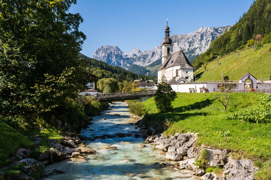 Scenic view of St Sebastian church in Ramsau with Ramsauer Ache river and Bavarian Alps
