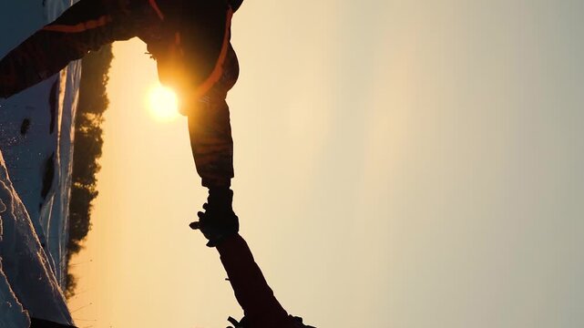 climbers go climbing the mountain forward. teamwork. travelers winter with backpacks sunset. climbing group people rise up. lifestyle love mountains adventure. active woman man teamwork give hand. sun