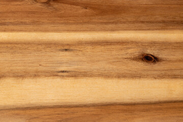 Fototapeta premium Natural light brown wooden board surface with organic grain patterns and dark knots showing detailed timber texture