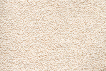 Top view of soft beige sherpa fleece texture with fluffy faux sheepskin surface and curly woolly material for cozy winter clothing background © agrus