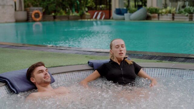 Couple doing ice bath at a luxury wellness retreat, practicing deep breathing to enhance cold therapy benefits, embracing mindfulness, biohacking, holistic recovery, and longevity in a serene setting