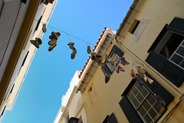 Chaussures suspendues à un fil dans une rue de Mahon sur l'île de Minorque
