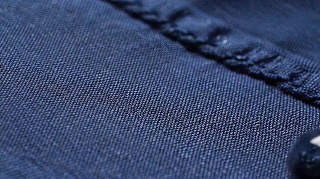 Gleaming miniature water beads gracefully cling to a deeply textured indigo denim surface, highlighting its remarkable hydrophobic properties and the intricate weave's innovative resilience.