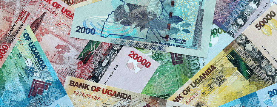 Ugandan shilling money banknotes pile on table. Uganda bills of UGX currency close up