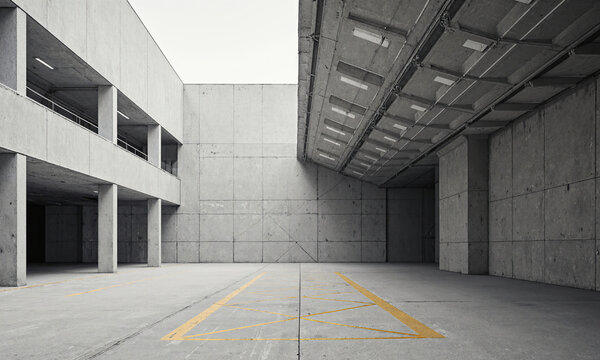 Concrete industrial warehouse empty courtyard with yellow floor markings and minimalist brutalist architecture for urban logistics and construction themes